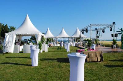 Vue aérienne d'un domaine rural avec bâtiments en pierre, arbres et vue sur une étendue d'eau calme en arrière-plan.