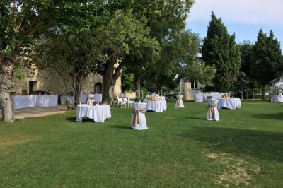 Vue aérienne d'un domaine rural avec bâtiments en pierre, arbres et vue sur une étendue d'eau calme en arrière-plan.