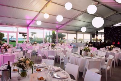 Vue aérienne d'un domaine rural avec bâtiments en pierre, arbres et vue sur une étendue d'eau calme en arrière-plan.