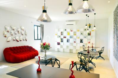 Vue aérienne d'un domaine rural avec bâtiments en pierre, arbres et vue sur une étendue d'eau calme en arrière-plan.