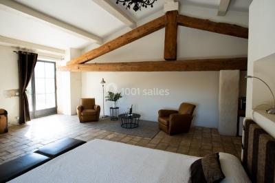 Vue aérienne d'un domaine rural avec bâtiments en pierre, arbres et vue sur une étendue d'eau calme en arrière-plan.