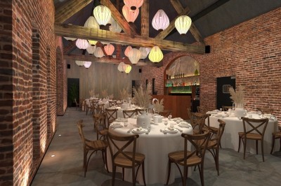 Salle de réception lumineuse avec tables rondes dressées, chaises en bois, plantes et murs en briques apparentes.