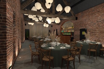 Salle de réception lumineuse avec tables rondes dressées, chaises en bois, plantes et murs en briques apparentes.