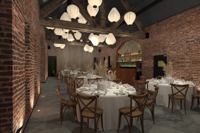 Salle de réception lumineuse avec tables rondes dressées, chaises en bois, plantes et murs en briques apparentes.