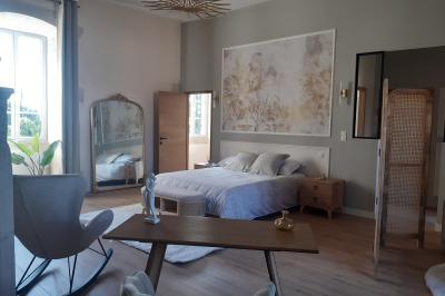Salle en pierre avec tables hautes noires, boissons, plantes décoratives et chaises disposées pour un événement.