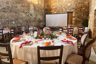 Miniature Location salle Bournezeau (Vendée) - Abbaye de Trizay #54 Cour intérieure d'un bâtiment historique en pierre, aménagée avec des tables hautes et éclairée par un soleil éclatant.
