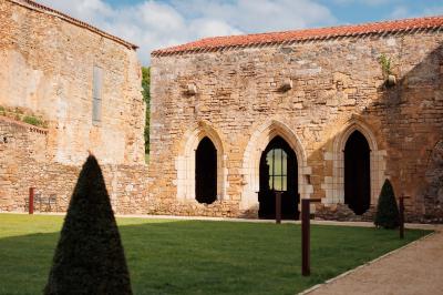 Table dressée avec nappes blanches, verres et seaux à glace, dans une salle en pierre avec de grandes fenêtres.