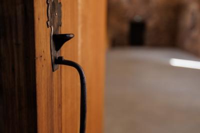 Table dressée avec nappes blanches, verres et seaux à glace, dans une salle en pierre avec de grandes fenêtres.