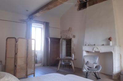 Table dressée avec nappes blanches, verres et seaux à glace, dans une salle en pierre avec de grandes fenêtres.