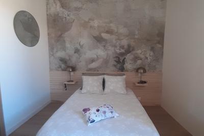 Table dressée avec nappes blanches, verres et seaux à glace, dans une salle en pierre avec de grandes fenêtres.