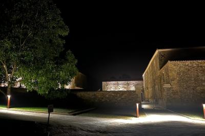 Table dressée avec nappes blanches, verres et seaux à glace, dans une salle en pierre avec de grandes fenêtres.