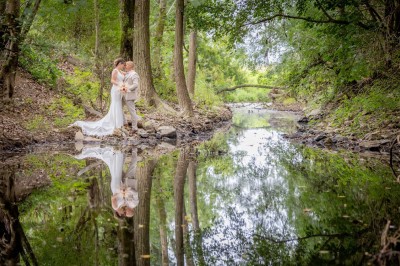 Table dressée avec nappes blanches, verres et seaux à glace, dans une salle en pierre avec de grandes fenêtres.