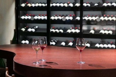 Chambre lumineuse sous combles avec poutres apparentes, lit à baldaquin, table en bois et fenêtre donnant sur l'extérieur.