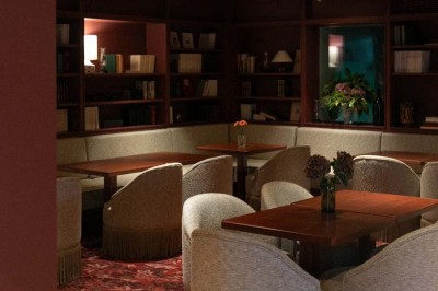 Chambre lumineuse sous combles avec poutres apparentes, lit à baldaquin, table en bois et fenêtre donnant sur l'extérieur.