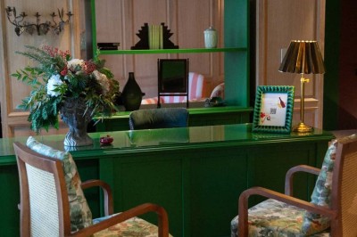 Chambre lumineuse sous combles avec poutres apparentes, lit à baldaquin, table en bois et fenêtre donnant sur l'extérieur.