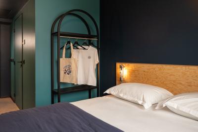 Douche avec carrelage blanc, robinetterie chromée, lavabo avec vase de fleurs séchées et flacon de savon.