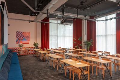 Couloir d'hôtel avec murs roses, moquette bleue à motifs et portes numérotées de chaque côté.