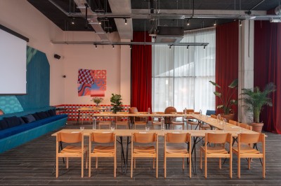 Couloir d'hôtel avec murs roses, moquette bleue à motifs et portes numérotées de chaque côté.