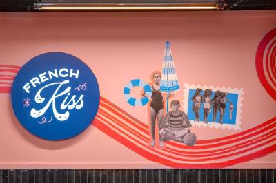 Douche avec carrelage blanc, robinetterie chromée, lavabo avec vase de fleurs séchées et savon.