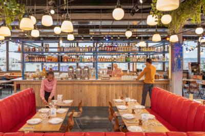 Douche avec carrelage blanc, robinetterie chromée, lavabo avec vase de fleurs séchées et savon.