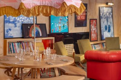 Douche avec carrelage blanc, robinetterie chromée, lavabo avec vase de fleurs séchées et savon.