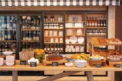 Douche avec carrelage blanc, robinetterie chromée, lavabo avec vase de fleurs séchées et savon.