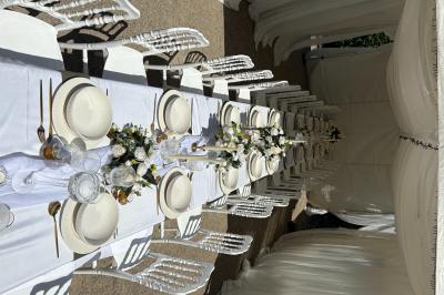 Bougies blanches et roses dans des vases en verre décorent une table recouverte d'une nappe blanche.