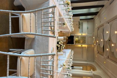 Bougies blanches et roses dans des vases en verre décorent une table recouverte d'une nappe blanche.