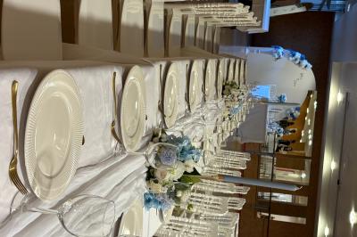 Bougies blanches et roses dans des vases en verre décorent une table recouverte d'une nappe blanche.