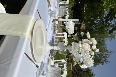 Bougies blanches et roses dans des vases en verre décorent une table recouverte d'une nappe blanche.
