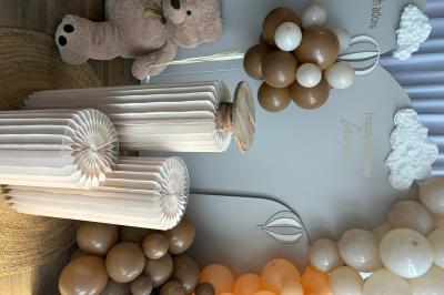 Bougies blanches et roses dans des vases en verre décorent une table recouverte d'une nappe blanche.