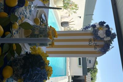 Bougies blanches et roses dans des vases en verre décorent une table recouverte d'une nappe blanche.