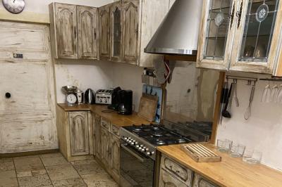 Voiture noire décorée de fleurs blanches et bleues, garée sur un parking près d'une pelouse.