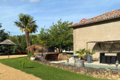 Voiture noire décorée de fleurs blanches et bleues, garée sur un parking près d'une pelouse.