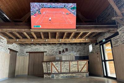 Cuisine professionnelle avec plans de travail en inox, évier, lave-vaisselle industriel et vue sur l'extérieur.