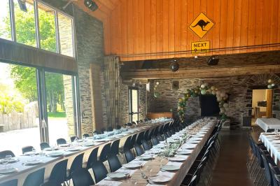 Cuisine professionnelle avec plans de travail en inox, évier, lave-vaisselle industriel et vue sur l'extérieur.