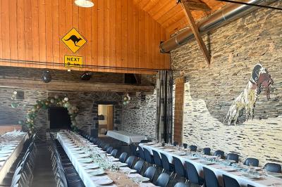 Cuisine professionnelle avec plans de travail en inox, évier, lave-vaisselle industriel et vue sur l'extérieur.