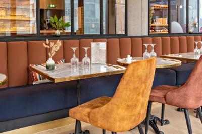 Salle de réunion avec une grande table en bois, entourée de fauteuils rembourrés, éclairée par une lampe et une fenêtre.