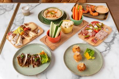 Salle de réunion avec une grande table en bois, entourée de fauteuils rembourrés, éclairée par une lampe et une fenêtre.