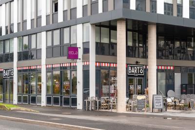 Salle de réunion avec une grande table en bois, entourée de fauteuils rembourrés, éclairée par une lampe et une fenêtre.