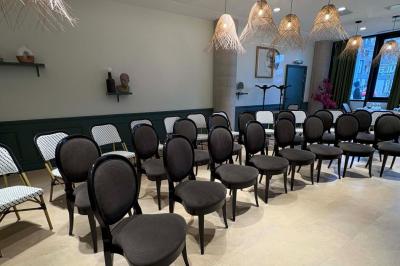 Salle de réunion avec une grande table en bois, entourée de fauteuils rembourrés, éclairée par une lampe et une fenêtre.