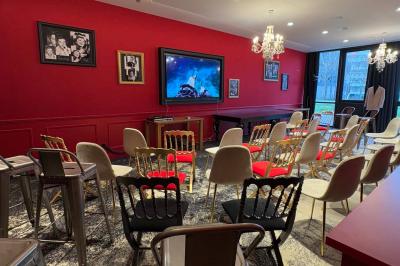 Salle de réunion avec une grande table en bois, entourée de fauteuils rembourrés, éclairée par une lampe et une fenêtre.