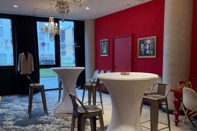 Salle de réunion avec une grande table en bois, entourée de fauteuils rembourrés, éclairée par une lampe et une fenêtre.