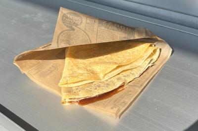 Façade d'un château en briques rouges et pierre claire avec tourelles, sous un ciel bleu partiellement nuageux.