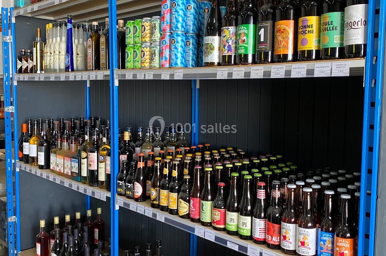 Étagères remplies de bouteilles d'alcool variées, incluant bières, vins et spiritueux, dans un magasin.