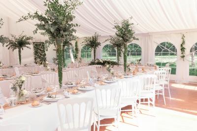 Chambre avec trois lits simples alignés, murs en pierre apparente, plafond en bois et lumière naturelle entrant par une…