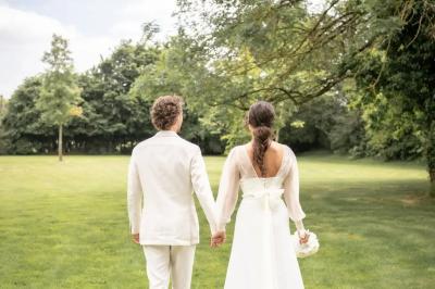 Chambre avec trois lits simples alignés, murs en pierre apparente, plafond en bois et lumière naturelle entrant par une…