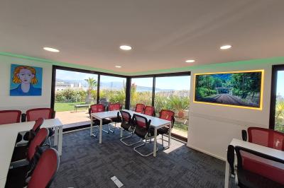 Double lavabo blanc avec robinets modernes, distributeur de savon mural et grand miroir éclairé en arrière-plan.