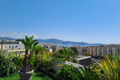 Double lavabo blanc avec robinets modernes, distributeur de savon mural et grand miroir éclairé en arrière-plan.