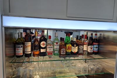 Double lavabo moderne avec robinets chromés, distributeur de savon mural et grand miroir éclairé en arrière-plan.